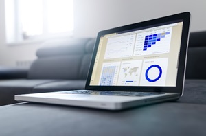 Ordinateur portable affichant des graphiques et des statistiques sur un écran, représentant l'analyse de données.