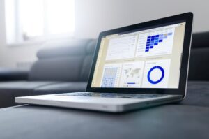 Un ordinateur portable affichant des graphiques et des données analytiques sur un canapé, symbolisant l'analyse de données.