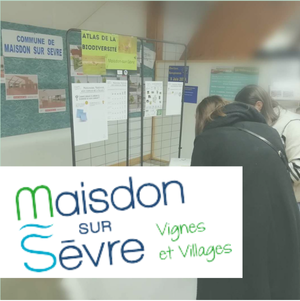 Des visiteurs consultent des panneaux sur la biodiversité et Maisdon-sur-Sèvre, avec le logo "Vignes et Villages" en avant-plan.