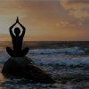 Conditions de travail Silhouette d'une personne en méditation sur une roche, face à la mer, avec un coucher de soleil en arrière-plan.